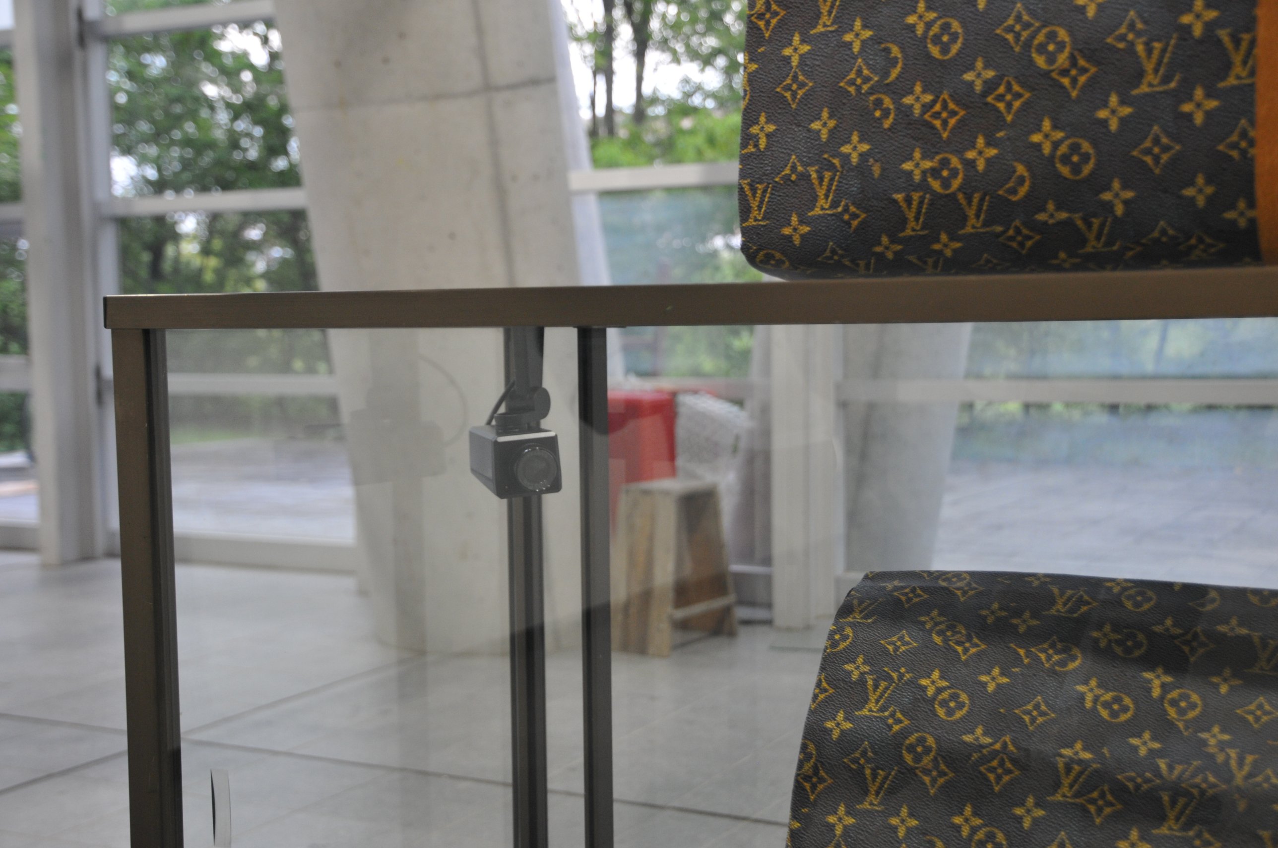 Close-up of the paper bags beside a small security camera mounted inside the showcase